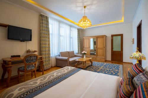 a hotel room with a bed and a living room at Navat Hotel in Bishkek