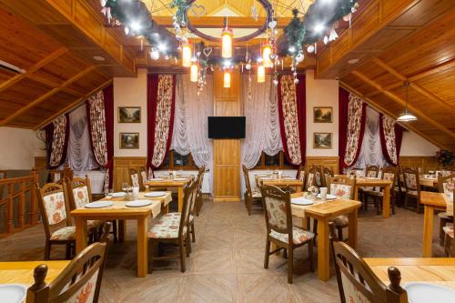 a restaurant with wooden tables and chairs and a television at Ganz SKI Lift 5 in Bukovel