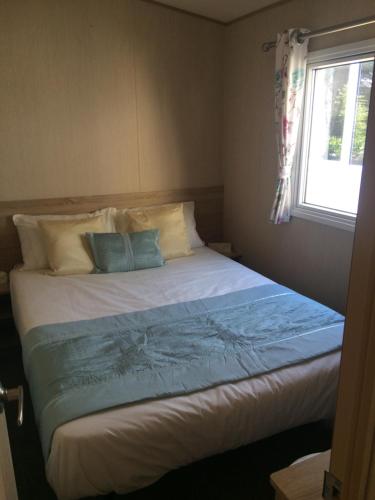 a bedroom with a large bed with a window at Isle of Wight Caravan in Shanklin