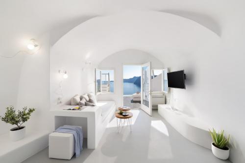 a white bathroom with a sink and a mirror at Marizan Caves & Villas in Oia
