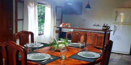 einen Esstisch mit Tellern und Weingläsern darauf in der Unterkunft Mi Jardín in San Rafael