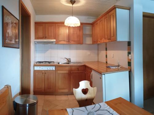 a kitchen with wooden cabinets and a sink at Apartma Bellevue Rogla in Vitanje