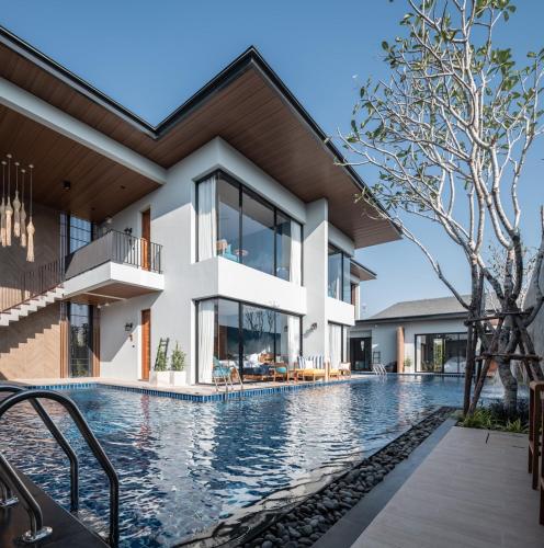an external view of a house with a swimming pool at Vann Hua Hin Resort in Cha Am