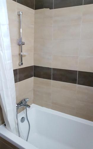 a bathroom with a bath tub with a faucet at Kerynia Apartments in Paphos