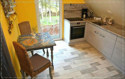 uma cozinha com mesa e cadeiras e uma cozinha com fogão em Ferienwohnung Heideschwedin l em Eschede