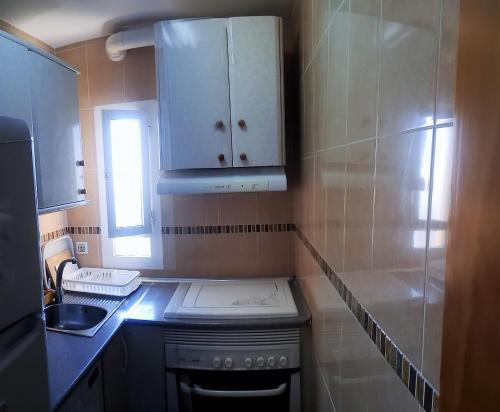 a small kitchen with a stove and a sink at Sol y relax, AGUILA in Benalmádena