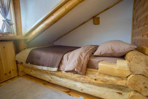 a bed in the attic of a log cabin at Durmitorske zore in Žabljak