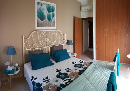 a bedroom with a bed with blue pillows at Kerynia Apartments in Paphos
