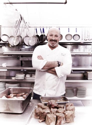 a chef standing in a kitchen with his arms crossed at Little River Inn in Little River