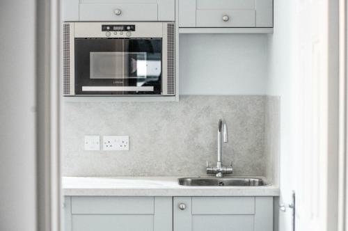 a kitchen with a sink and a microwave at Dukes Inn in Sidmouth