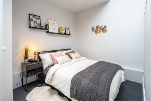 um quarto com uma cama e uma mesa de cabeceira com uma cama sidx sidx sidx sidx em Kensington Modern Apartment em Londres