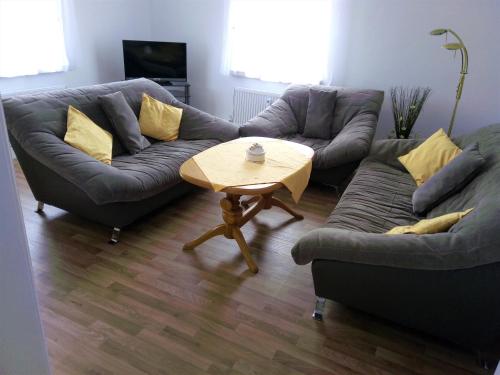 Sala de estar con 2 sofás y mesa de centro en Ferienwohnung Familie Schneider en Neustadt in Sachsen