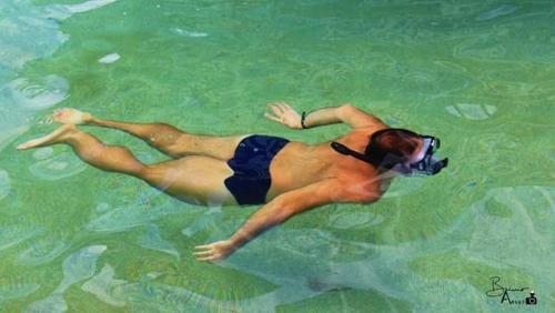 a woman swimming in the water in the ocean at Hotel Castelo La Paloma in Gamboa