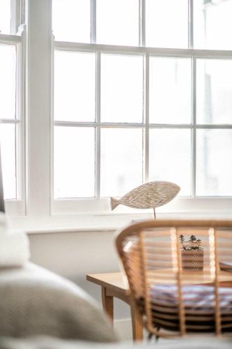 a room with windows and a chair and a table at Dukes Inn in Sidmouth