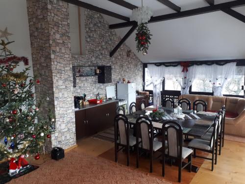 a dining room with a table and a christmas tree at CASA DINTRE PINI in Păltinoasa