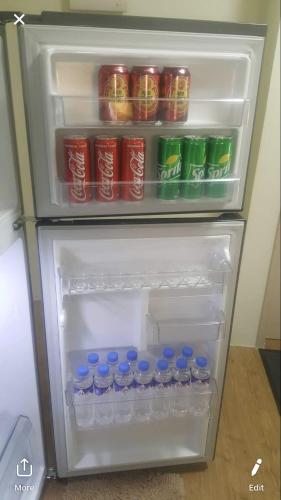 an open refrigerator with drinks and cans of soda at San Remo Oasis SRP Cebu in Cebu City
