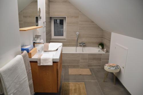 a bathroom with a sink and a bath tub at Plumes et Pinceaux in Redu