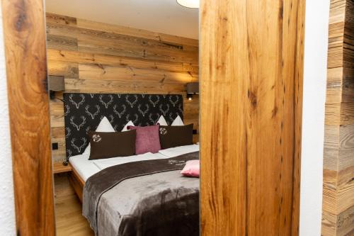 a bedroom with a bed and a wooden wall at Appartements Lehenhof in Sankt Johann im Pongau