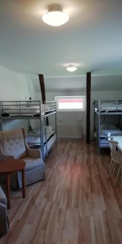 a room with bunk beds and a couch and a table at Baggetorps Vandrarhem in Vallhalla