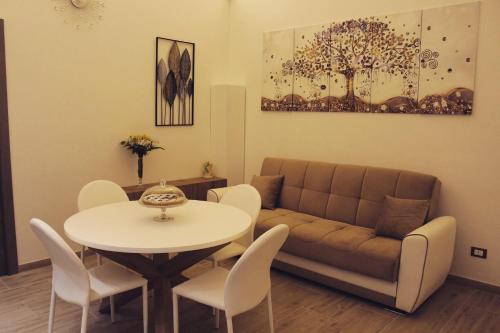 ein Wohnzimmer mit einem Tisch und einem Sofa in der Unterkunft Duecuori & Una spa in Lecce