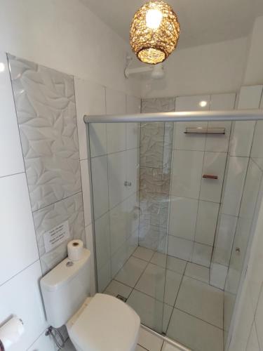 a bathroom with a toilet and a glass shower at Pousada Solar Azul in Lençóis