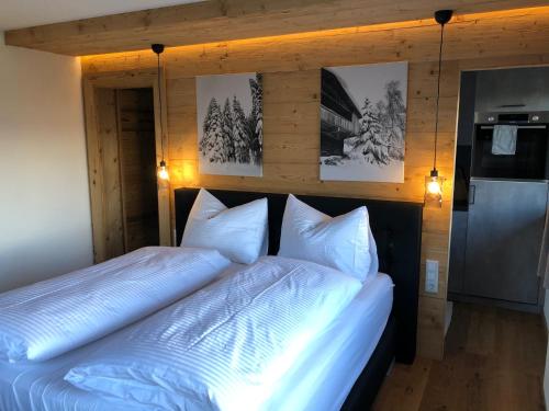 a bedroom with two beds and pictures on the wall at Schwarzenbergerhof in Reith im Alpbachtal