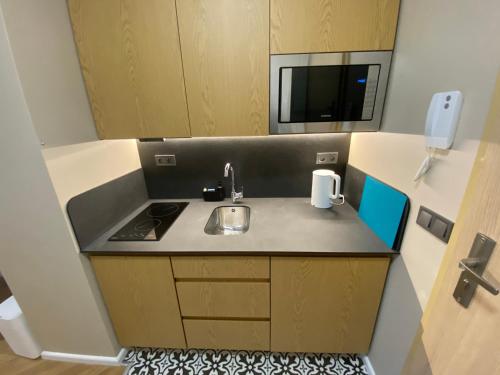 a small kitchen with a sink and a microwave at Apartament Wrocław Marina nad Odrą 29 in Wrocław