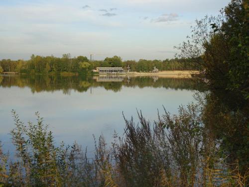 a lake with a dock in the middle of it at Ferienhaus Nr 6 am Quendorfer See in Schüttorf