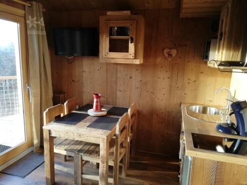 a small kitchen with a wooden table and a sink at Ma Cabane des Hautes-Alpes in Saint-Julien-en-Champsaur