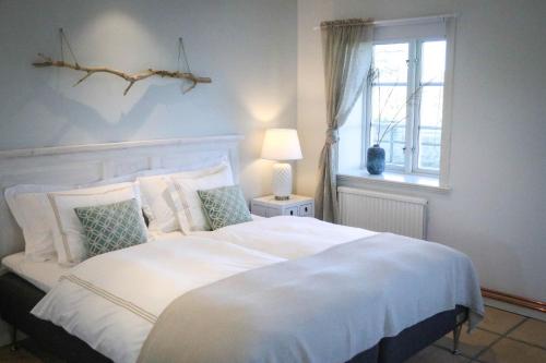 Schlafzimmer mit einem großen weißen Bett und einem Fenster in der Unterkunft SOEDER Countryhouse & Kitchen in Båstad