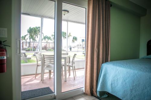 a bedroom with a sliding glass door with a table and chairs at Ragged Edge Resort & Marina in Islamorada