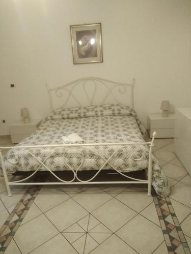 a white bed in a bedroom with a picture on the wall at House 123 in Sorso