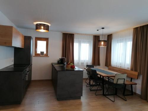 una cucina e una sala da pranzo con tavolo e sedie di Studler Hofchalets a Oberperfuss