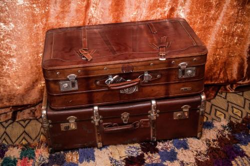 two suitcases stacked on top of each other on a rug at Camp Cameleon in Marrakech