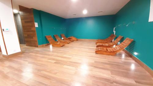 a room with wooden chairs and a blue wall at SEA & YOU Apartament z widokiem na morze - Dwie Sosny in Ustronie Morskie