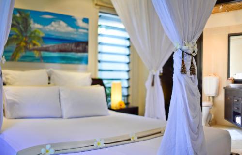 a bedroom with a white bed and a window at Taveuni Palms Resort in Matei