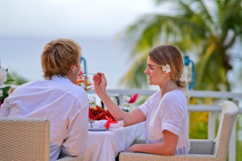 um homem e uma mulher sentados à mesa em Taveuni Palms Resort em Matei