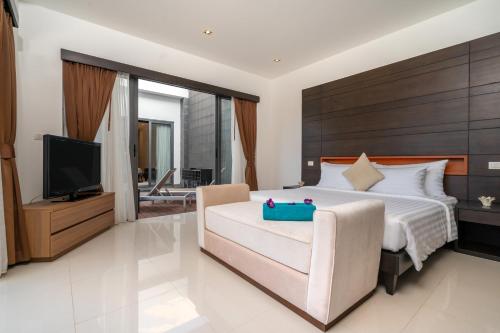 ein Schlafzimmer mit einem großen Bett und einem TV in der Unterkunft The Harmony Pool Villa Phuket in Strand Bang Tao