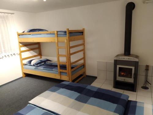 a bedroom with bunk beds and a wood stove at Apartmány Pod strání in Vrchlabí