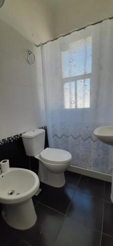 a bathroom with two toilets and a sink and a window at Hotel Rivadavia in Piriápolis