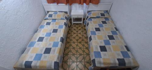 a room with two beds in a room at Hotel Rivadavia in Piriápolis