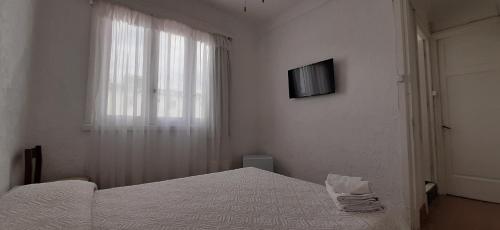 a bedroom with a bed and a television on the wall at Hotel Rivadavia in Piriápolis