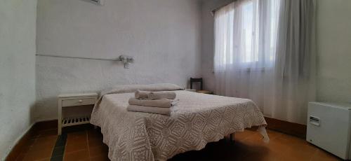 a bedroom with a bed with towels on it at Hotel Rivadavia in Piriápolis