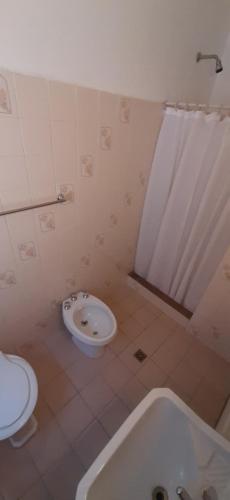 a bathroom with a tub and a toilet and a sink at Hotel Rivadavia in Piriápolis