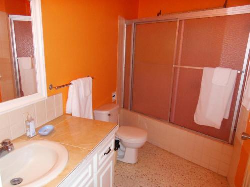 a bathroom with a toilet and a sink and a shower at Whistling Villa Runaway Bay in Runaway Bay