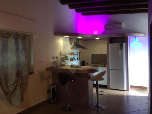 een keuken met een bar met roze verlichting bij Oasi Love in Fiumefreddo di Sicilia