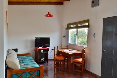 - un salon avec une table, des chaises et une télévision dans l'établissement View Point Apart Nogal, à Villa Giardino