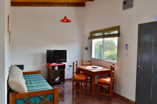 Una sala de estar con una mesa y sillas y un televisor. en View Point Apart Nogal, en Villa Giardino
