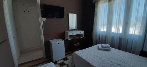 a hotel room with a bed and a television at Hotel Rivadavia in Piriápolis