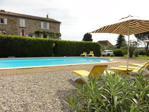 a swimming pool with chairs and an umbrella at Gîte La Jaujon in Lablachère